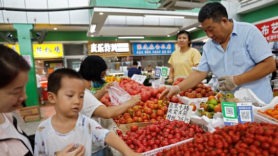 Customers at a produce market in Beijing.