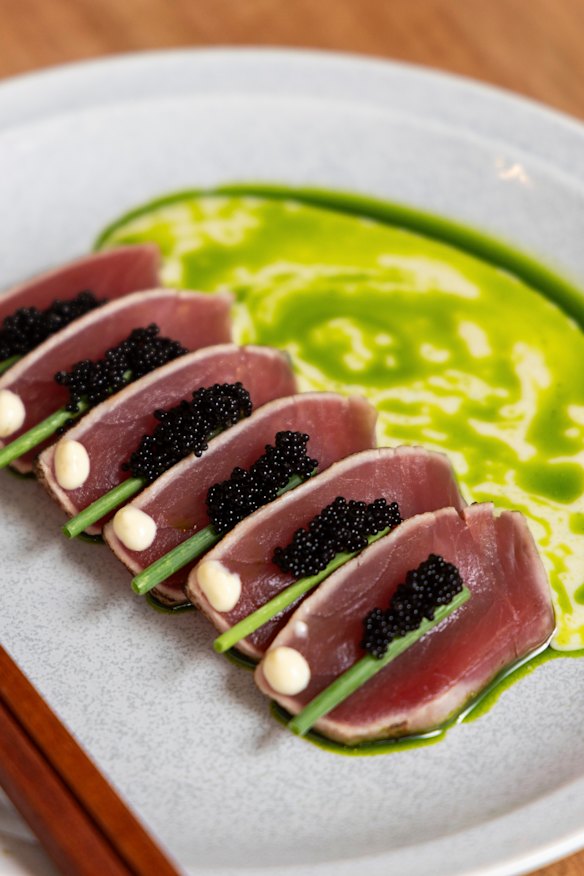 Tuna carpaccio featuring square slices of aged tuna carefully garnished with flying fish roe, chives and spiced yuzu mayo.