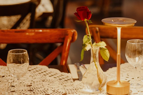 Freshly cut red roses are set on each table.