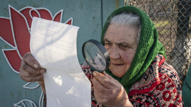 A woman examines her ballot paper in Mariinka, eastern Ukraine.