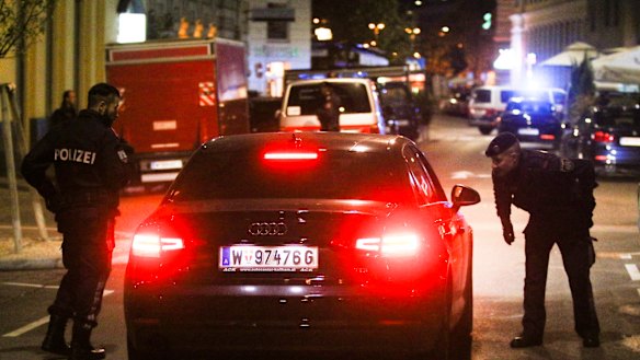 Police officers check a car at the scene after the attack in Vienna.