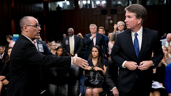 Fred Guttenberg, whose daughter Jamie was killed in a school shooting, attempts to shake hands with Brett Kavanaugh.
