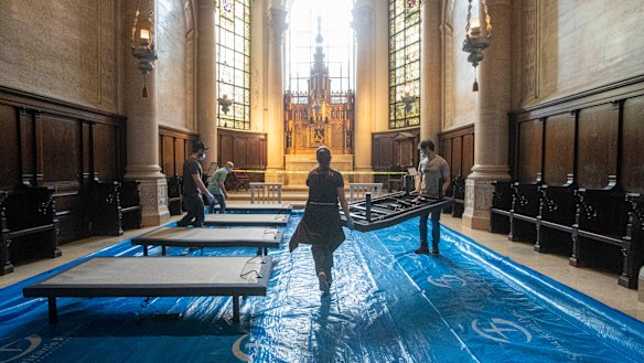 Volunteers place beds in a chapel while building a field hospital at the Cathedral of St. John the Divine, in New York. 