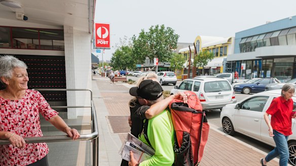 Ms Hunt, left, with post office employee Elise and one of the mail deliverers. 