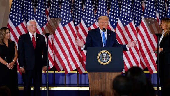 President Donald Trump speaks in the East Room of the White House, early on Wednesday in Washington, as Vice President Mike Pence and Karen Pence and first lady Melania Trump listen. 