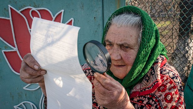 A woman examines her ballot paper in Mariinka, eastern Ukraine.