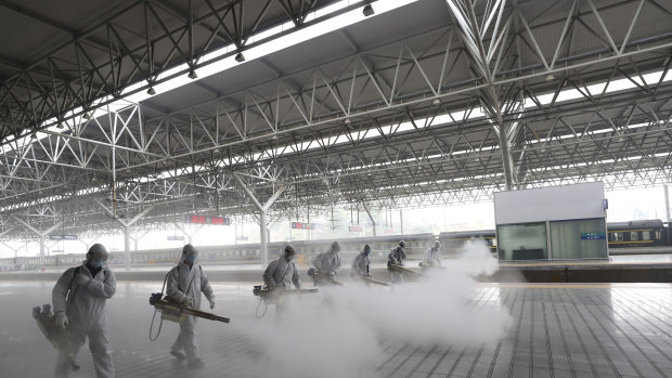 Firefighters conduct disinfection on the platform at a railway station before Wuhan's transport networks reopened in March. 