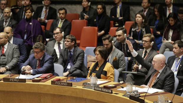 Russian Ambassador to the United Nations Vasily Nebenzya, right, votes against a resolution concerning Venezuela during a Security Council meeting at UN headquarters in New York.