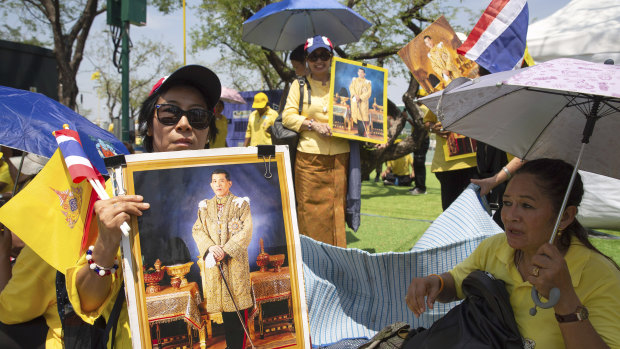 Well wishers with portraits of the new  King gather outside Bangkok's Grand Palace.  
