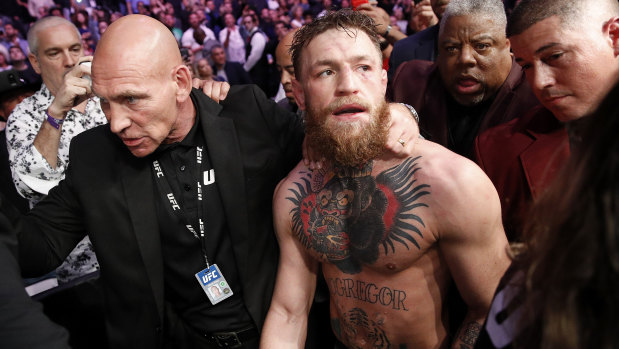 Conor McGregor is led away by security after the post-fight drama.