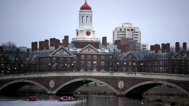 Rowers paddle down the Charles River past the campus of Harvard University in Cambridge, Massachusetts. 