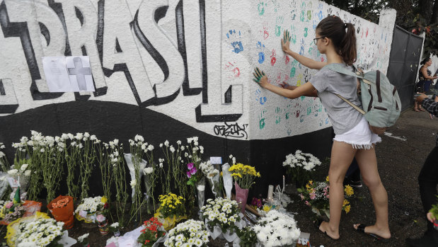 A student places her handprints on a wall at Raul Brasil State School. 