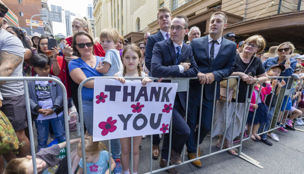 Erin Marsh, 9, is seen holding a "Thank You" sign in the crowd during the Anzac Day parade in Brisbane.