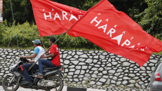Supporters ride with flags of Pakatan Harapan (Alliance of Hope) as Anwar Ibrahim arrives at a polling station in the southern coastal town of Port Dickson.