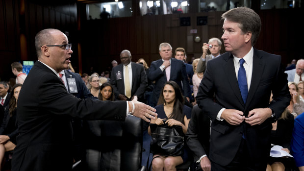 Fred Guttenberg, whose daughter Jamie was killed in a school shooting, attempts to shake hands with Brett Kavanaugh.