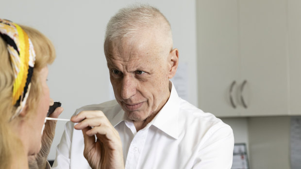 Dr Harry Nespolon , pictured taking a throat swab, says GPs can't categorically rule out coronavirus infection.