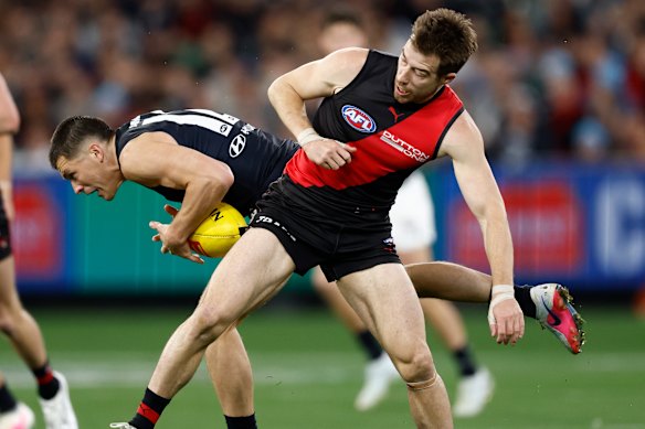 Ben Ainsworth of the Blues is bumped by Zach Merrett of the Bombers.
