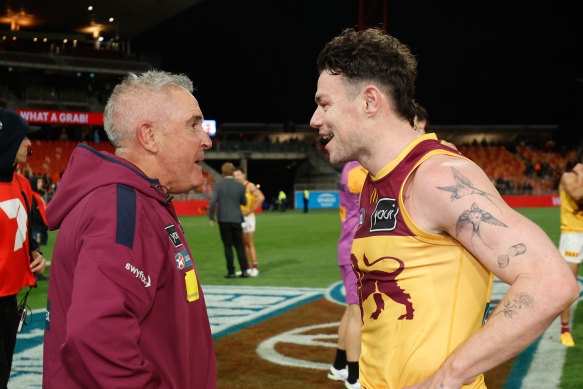 Lachie Neale of the Lions celebrates with coach Chris Fagan.