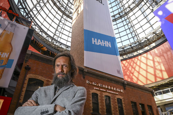 Founder of the Heritage Network Victoria, Adam Ford, in front of the Coop’s Shot Tower blanketed in a beer ad.