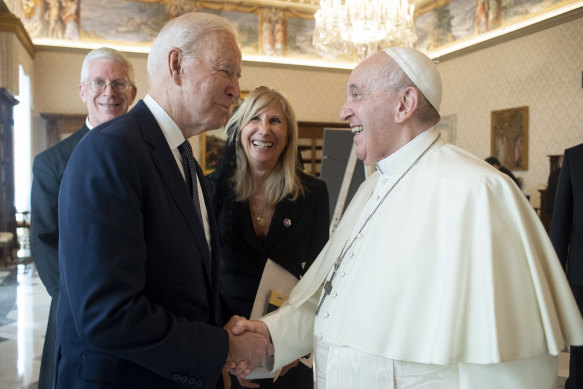 US President Joe Biden, left, shakes hands with Pope Francis at the Vatican.
