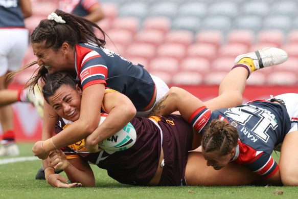 Millie Boyle crashes through a Roosters tackle.