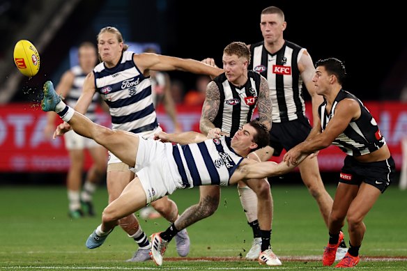Oisin Mullin hits the ball out of bounds as he is tackled by Nick Daicos.