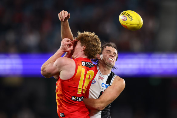 Matt Rowell of the Suns (L) is challenged by Hunter Clark of the Saints.