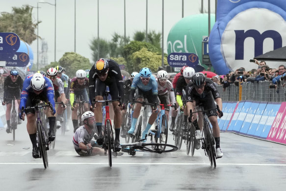 Mark Cavendish crashes in the final metres of stage 5 as Kaden Groves (left) nudges ahead for the win.
