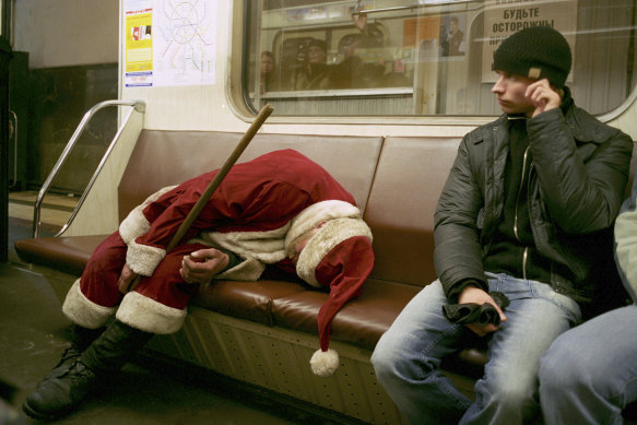 A drunk man dressed as Santa Claus sleeps on an underground train in Moscow.