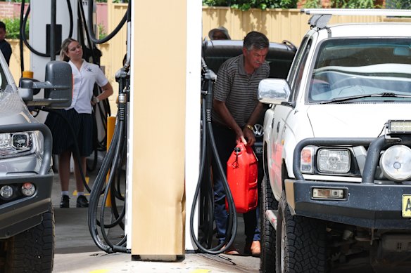 A man fills jerry cans at a petrol station in Sydney. 