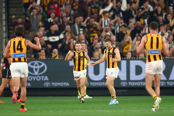 Dylan Moore of the Hawks celebrates after he kicked a goal on the siren for the match to end in a draw.