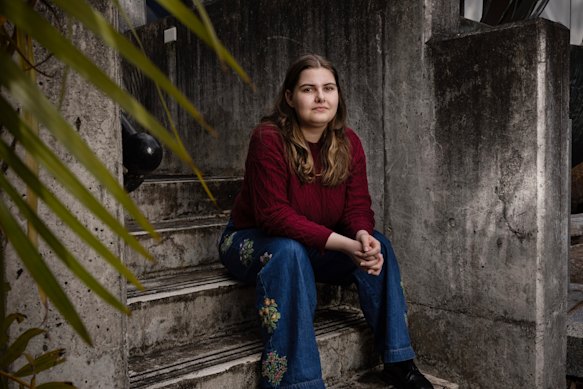 Sophia Mullard sits on the steps at Macquarie University’s department of media, music, communication and cultural studies. She dreamt of attending Macquarie but feels course cuts have ruined her plans. 