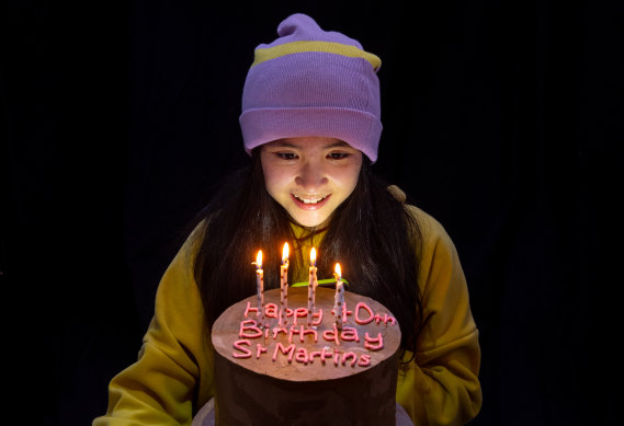 St Martins student Eve Feng, 12, with a cake marking the 40th anniversary.