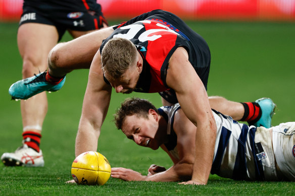 Jake Stringer of the Bombers and Mitch Duncan of the Cats compete for the ball .