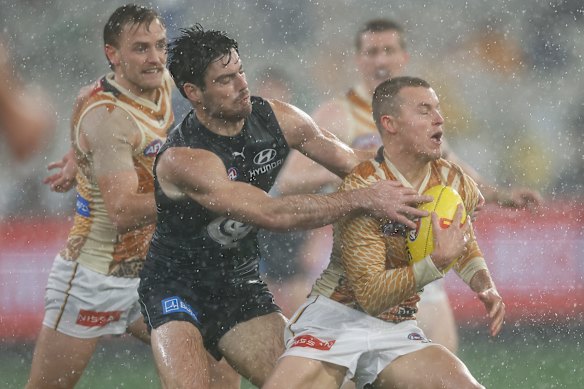 Jack Ginnivan dos Hawks é abordado por George Hewett dos Blues.