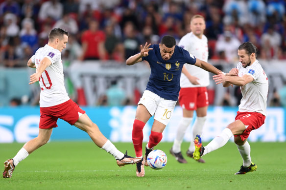 Unstoppable: Kylian Mbappe shrugs off Poland’s Piotr Zielinski and Grzegorz Krychowiak.