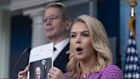 White House press secretary Karoline Leavitt with Treasury Secretary Scott Bessent, back left, shows a picture of Jeff Besos as she responds to a question about Amazon, during a briefing in the James Brady Press Briefing Room at the White House, Tuesday, April 29, 2025, in Washington. (AP Photo/Manuel Balce Ceneta)