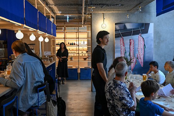 Bright blue noren (bunting) surrounds the bar counter at Ima Asa Yoru in Brunswick.