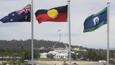 The Australian flag,  the Aboriginal flag and the Torres Strait Islander flag flying in Canberra.