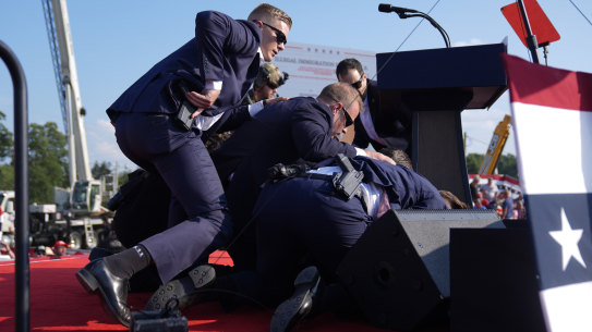 US Secret Service agents move to cover the former president.