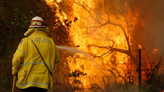 A Tuncurry fire crew member fights part of the Hillville bushfire south of Taree on the NSW Mid North Coast.