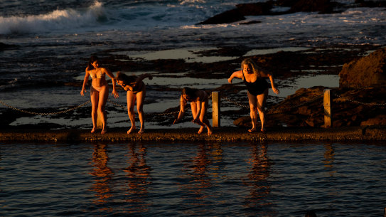 After viewing the sunrise,  a group of swimmers dive into Mahon Pool at Maroubra, on the last day of winter, in Sydney. 