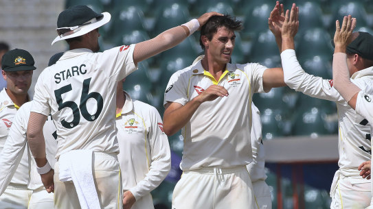 Australian captain Pat Cummins celebrates a Pakistan wicket with teammates on the final day of the third Test.