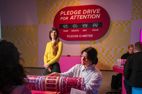 American artist Laura Allcorn (yellow top) with her work Pledge Drive For Attention.
