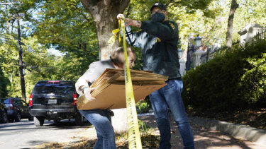 A federal agent walks boxes to a home of Russian oligarch Oleg Deripaska in Washington, DC.