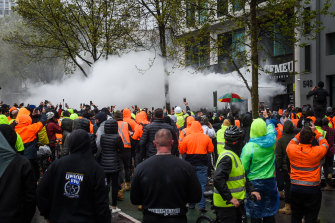 People inside the CFMEU office fend off protesters with fire extinguishers on Monday.