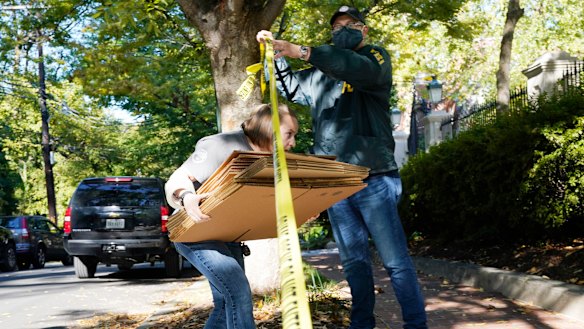 A federal agent walks boxes to a home of Russian oligarch Oleg Deripaska in Washington, DC.