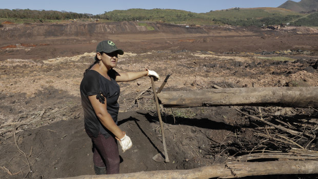 Tereza Nascimento pauses as she digs in search of her missing brother Paulo Santos' body, using garden tools, at the site of the Brumadinho dam disaster.