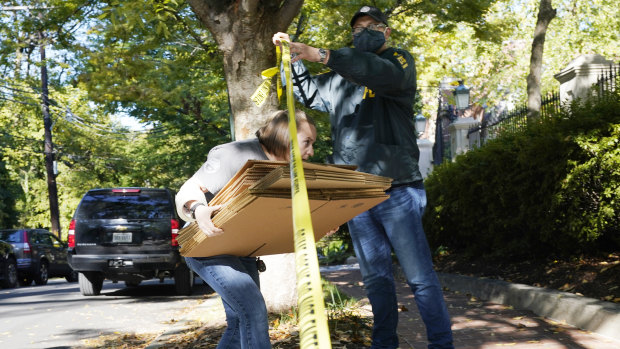 A federal agent walks boxes to a home of Russian oligarch Oleg Deripaska in Washington, DC.