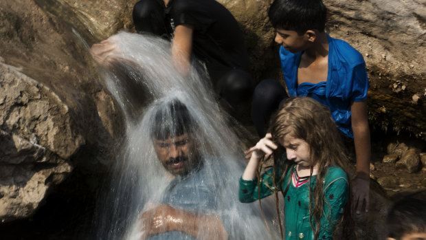 A family cools off in a stream during a heat wave in Pakistan in 2017.